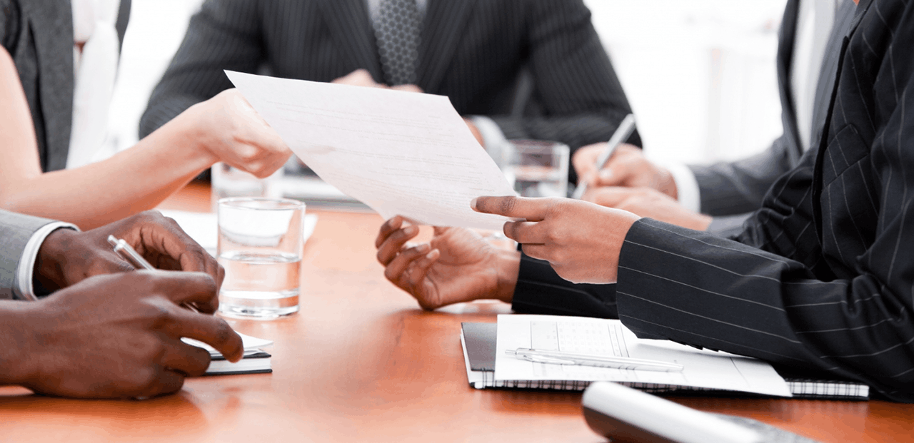 People discussing documents at an office table.
